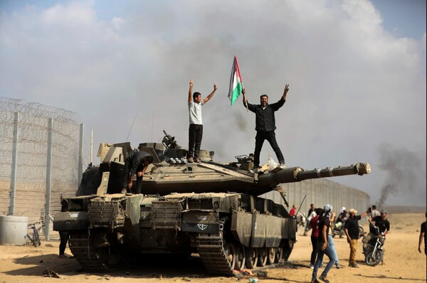 프리랜서 사진기자 유세프 마수드가 지난 7일 AP통신에 제공한 사진. 파괴된 이스라엘군 탱크 위에서 가자 현지인들이 환호하고 있는 모습이다. 