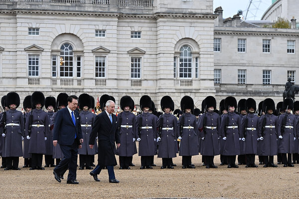 영국을 국빈 방문한 윤석열 대통령이 21일(현지시간) 런던 호스가즈 광장에서 열린 공식 환영식에서 찰스 3세 국왕과 왕실 근위대를 사열하고 있다. [공동취재]