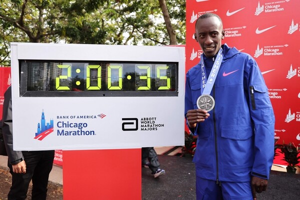 케냐의 켈빈 키프텀이 지난해 10월 8일 시카고 마라톤에서 2시간00분35초의 세계신기록을 세우며 우승한 뒤 자신의 기록이 찍힌 전광판 앞에서 메달을 목에 걸고 포즈를 취하고 있다. [AFP연합]