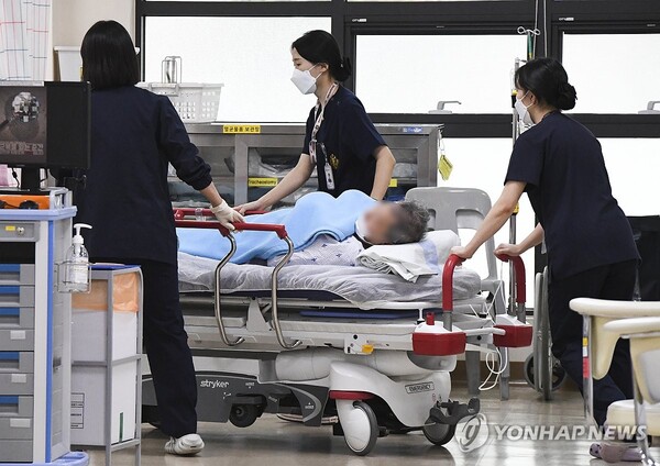 정부가 20일 군 병원 12곳 응급실을 민간인에게 개방하면서 이날 오후 의료진들이 경기 성남시 국군수도병원 응급실로 민간인 환자를 옮기는 모습. [사진=연합뉴스]