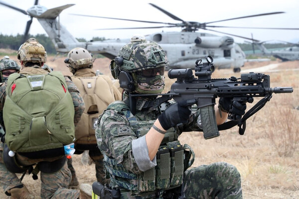 지난해 3월 22일 경북 포항의 한 훈련장에서 실시된 한·미·영 수색부대의 연합작전 수행능력 훈련 기간 중  미국 해병대 CH-53E 대형수송헬기 주변에서 한국 해병대원이 경계하고 있다. [연합뉴스]