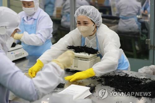 김혜경 여사가 지난 2022년 1월 18일 전북 부안군 장애인 근로사업장인 '바다의 향기'에서 작업하는 모습. [사진=연합뉴스]