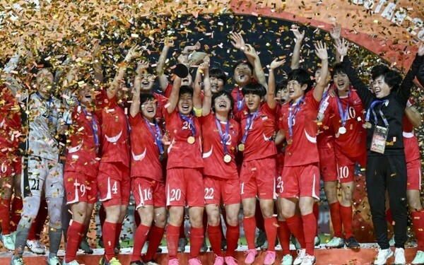 북한이 아시아축구연맹(AFC) 여자 아시안컵 결승전에서 일본에 2-1로 승리하며 우승을 확정 지은후 우승컵을 들어 올리며 환호하고 있다. [AFC 홈페이지 캡처]